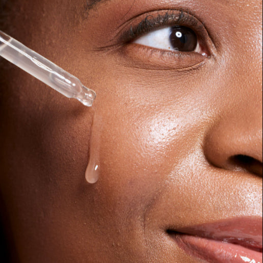 Dry Skin_model applying serum to her cheek close up